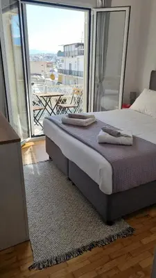 a bed in a room with a large window at Palaio Faliro Breeze in Athens