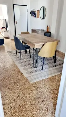 a dining room with a table and chairs on a rug at Palaio Faliro Breeze in Athens