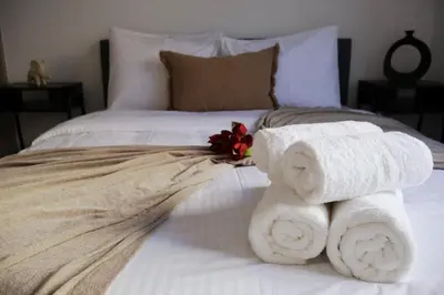 a bed with two rolled towels and a flower on it at Athenean Porto Pireaus Suites-B1 in Piraeus