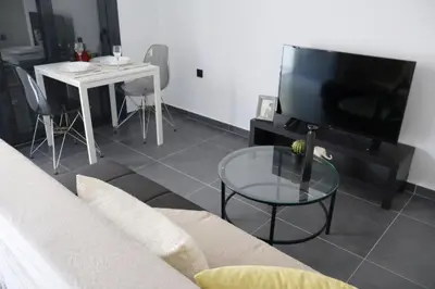 a living room with a couch and a table and a tv at Athenean Porto Pireaus Suites-B1 in Piraeus