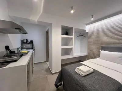 a small bedroom with a bed and a kitchen at MetroSide & Concert Hall Studio by ΜΡS in Athens