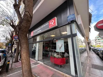 a store front with red chairs in front of a building at MetroSide & Concert Hall Studio by ΜΡS in Athens
