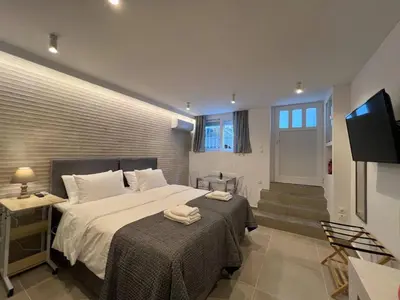 a bedroom with a large bed and a television at MetroSide & Concert Hall Studio by ΜΡS in Athens