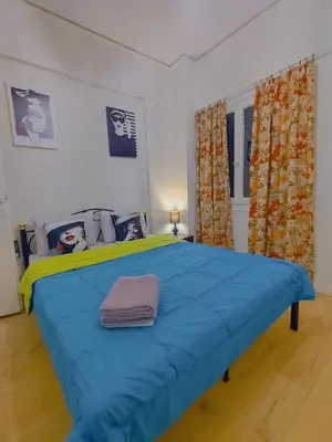 a large blue bed in a room with curtains at Old area of Athens in Athens