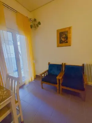 a living room with a blue couch and a table at Old area of Athens in Athens