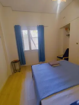 a bedroom with a blue bed and a window at Old area of Athens in Athens