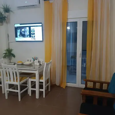 a dining room with a table and chairs and a television at Old area of Athens in Athens