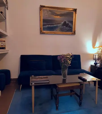 a living room with a blue couch and a table at Old area of Athens in Athens