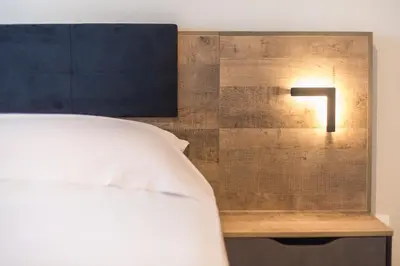 a light on a wall next to a bed at Eudoxus Haus in Athens