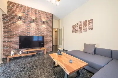 a living room with a couch and a tv at Eudoxus Haus in Athens