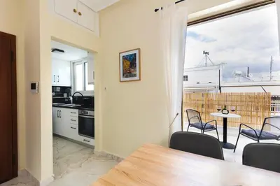 a kitchen and dining room with a table and chairs at Pagrati Sunlit Penthouse in Athens