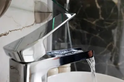 a faucet with water pouring into a sink at Pagrati Sunlit Penthouse in Athens
