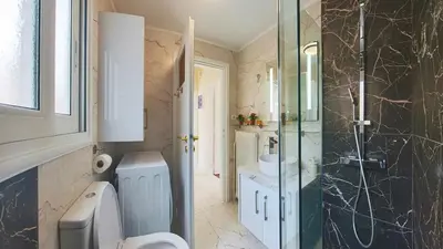 a bathroom with a shower and a toilet and a sink at Pagrati Sunlit Penthouse in Athens