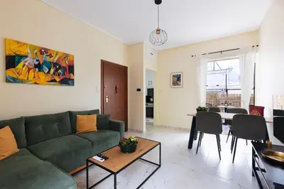 a living room with a green couch and a table at Pagrati Sunlit Penthouse in Athens
