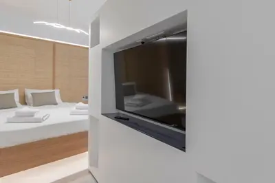 a room with a bed and a tv on a wall at Staiko Apartment in Athens