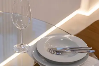 a plate and a wine glass on a glass table at Staiko Apartment in Athens