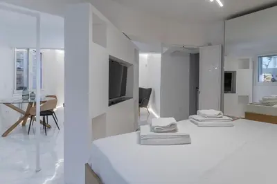 a white room with three pillows on a bed at Staiko Apartment in Athens
