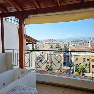 a balcony with a tub and a view of a city at Acropolis View Sky Suite with Jacuzzi near Metro in Athens