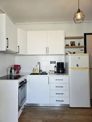 a white kitchen with white appliances and white cabinets at Acropolis View Sky Suite with Jacuzzi near Metro in Athens
