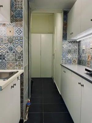 a kitchen with white cabinets and tiles on the walls at Syntagma Artist Apartment 2BR 8G in Athens