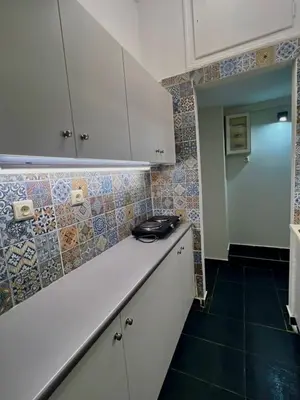 a kitchen with white cabinets and tiles on the wall at Syntagma Artist Apartment 2BR 8G in Athens