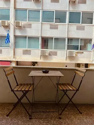 a table and two chairs in front of a building at Syntagma Artist Apartment 2BR 8G in Athens
