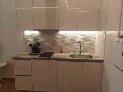 a kitchen with white cabinets and a sink at Modern familiar house under Acropolis in Athens