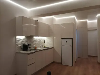 a kitchen with white cabinets and a refrigerator at Modern familiar house under Acropolis in Athens