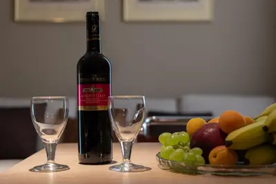 a bottle of wine next to two glasses on a table at Syntagma Zairas Hideaway! in Athens