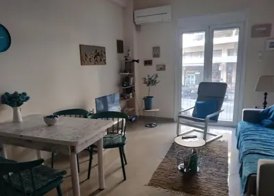 a living room with a table and chairs and a couch at 2room-flat, perfect kitchen in Athens, Pangkrati 100Μbits in Athens