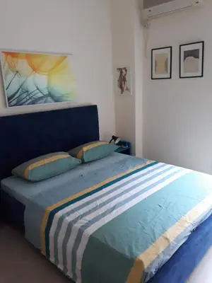a bedroom with a large bed with a striped blanket at 2room-flat, perfect kitchen in Athens, Pangkrati 100Μbits in Athens