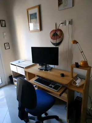 a desk with a computer monitor and a blue chair at 2room-flat, perfect kitchen in Athens, Pangkrati 100Μbits in Athens
