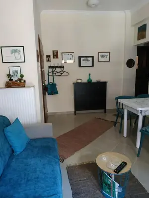 a living room with a blue couch and a table at 2room-flat, perfect kitchen in Athens, Pangkrati 100Μbits in Athens