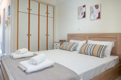 a bedroom with a large white bed with towels on it at Welcome apartment in Athens
