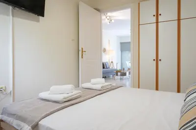 a bedroom with a white bed with towels on it at Welcome apartment in Athens