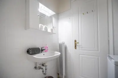 a white bathroom with a sink and a mirror at Welcome apartment in Athens