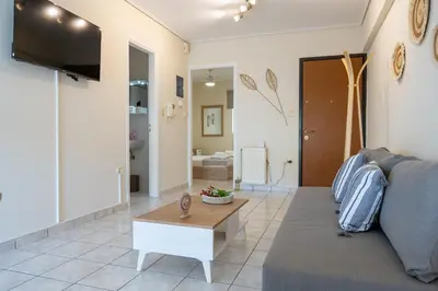 a living room with a couch and a table at Welcome apartment in Athens
