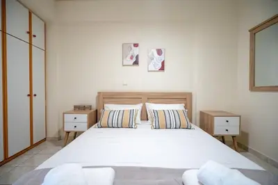 a bedroom with a large white bed with two night stands at Welcome apartment in Athens