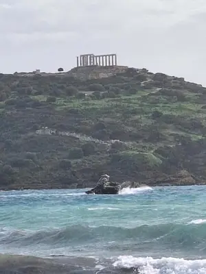 an island in the ocean with a lighthouse on a hill at S&M Cozy Garden Lagonissi in Lagonissi