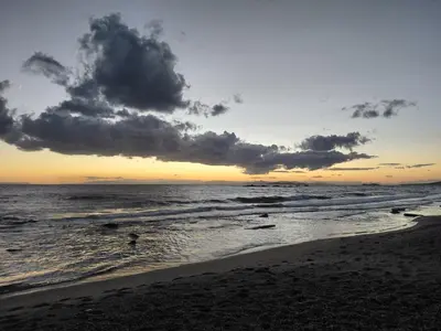 a sunset on a beach with the ocean at S&M Cozy Garden Lagonissi in Lagonissi