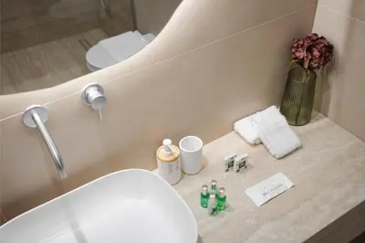 a bathroom with a sink and a toilet and a mirror at Glyfada Prime Living in Athens
