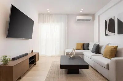 a living room with a couch and a tv at Glyfada Prime Living in Athens