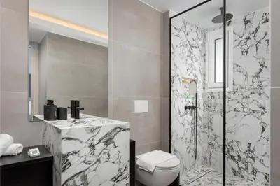 a bathroom with a shower and a toilet and a sink at Glyfada Prime Living in Athens