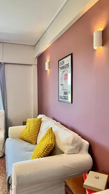 a room with two beds and a wall with a picture at Beach house in the heart of Athens Riviera in Athens