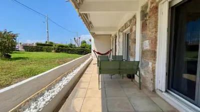 a porch of a house with a green bench at Beach house in the heart of Athens Riviera in Athens