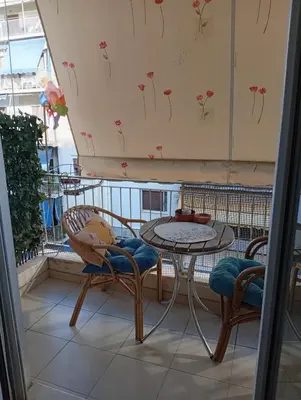 a balcony with a table and chairs on a balcony at Athens Panormou station in Athens