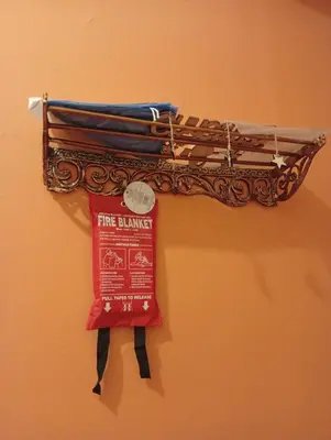 a metal instrument hanging on a wall with a red ribbon at Athens Panormou station in Athens