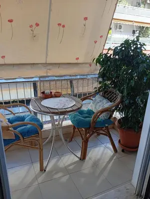 a table and chairs on a balcony with plants at Athens Panormou station in Athens