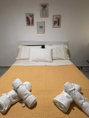 a bedroom with a bed with two towels on it at Minimal Above in Paianía