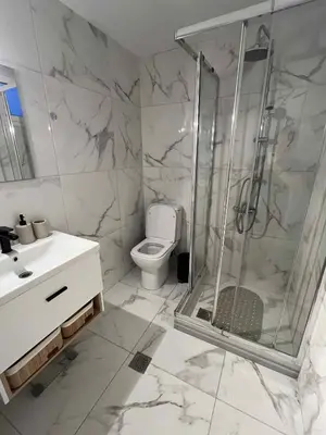 a bathroom with a shower and a toilet and a sink at Minimal Above in Paianía